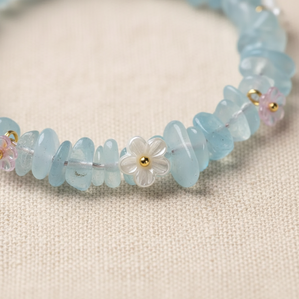 White shell and pink flower charms with gold ring connectors close-up