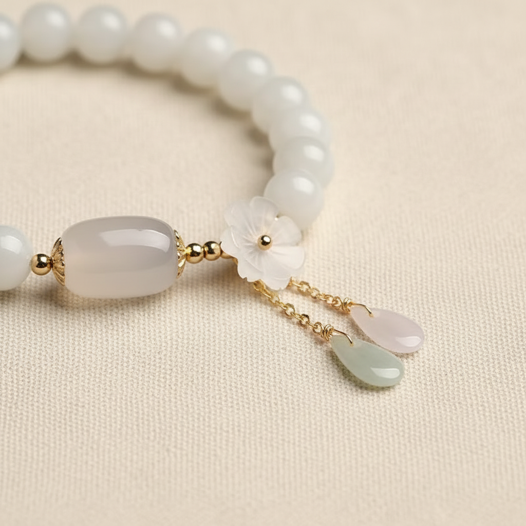 Carved shell flower and jade teardrop pendant close-up