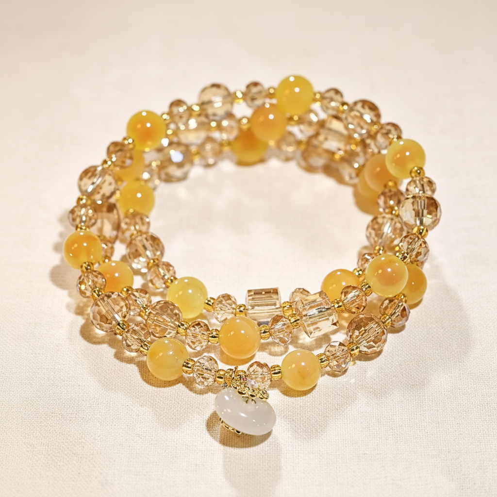 Yellow Agate & Champagne Crystal Triple-Wrap Bracelet flat lay on warm cream linen